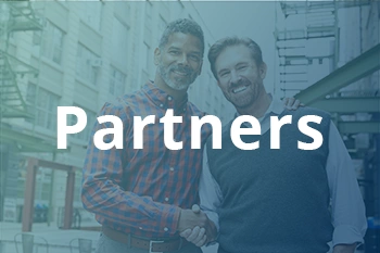 Two men shaking hands outside workplace to signify partnership