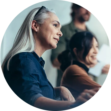 Striven referral program - referring person looks at colleagues in a meeting
