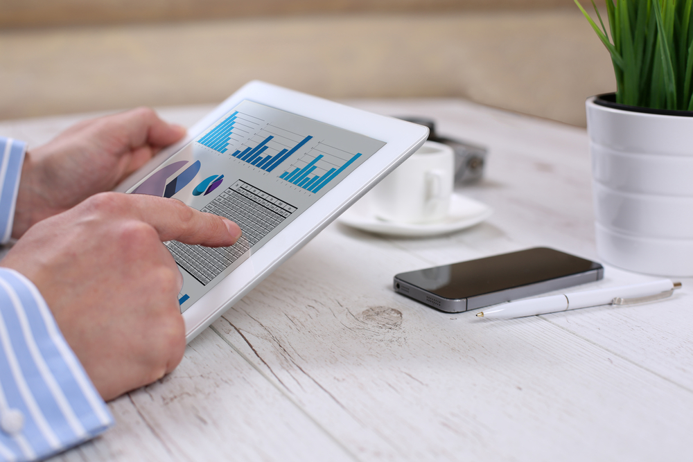 man holding tablet with erp system interface